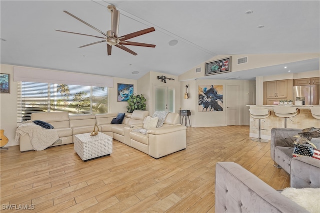 living room featuring ceiling fan, light wood-type flooring, and vaulted ceiling