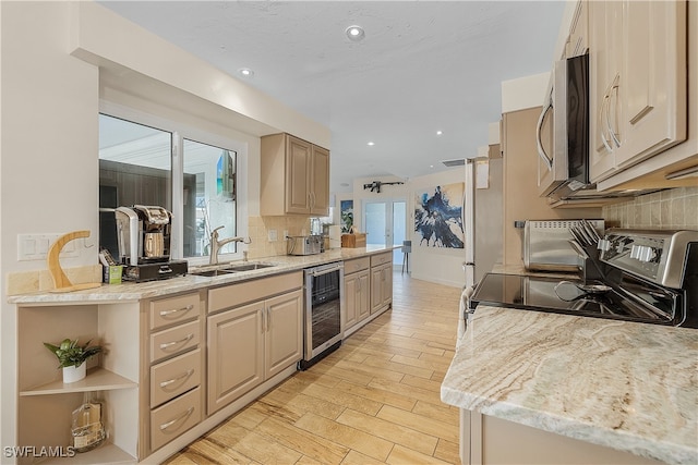 kitchen with decorative backsplash, stainless steel appliances, beverage cooler, sink, and light brown cabinets