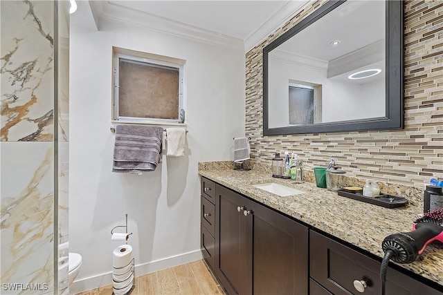 bathroom featuring tasteful backsplash, crown molding, hardwood / wood-style floors, toilet, and vanity