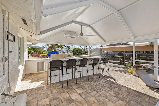 view of patio featuring ceiling fan and an outdoor bar