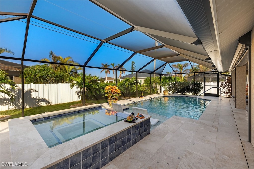 view of swimming pool featuring a patio area, a lanai, and an in ground hot tub