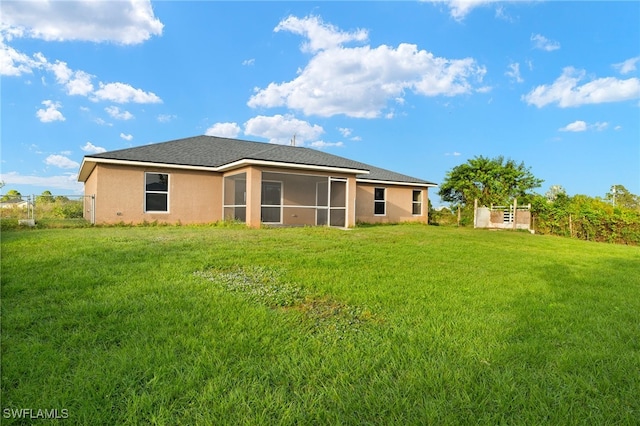 rear view of house featuring a lawn