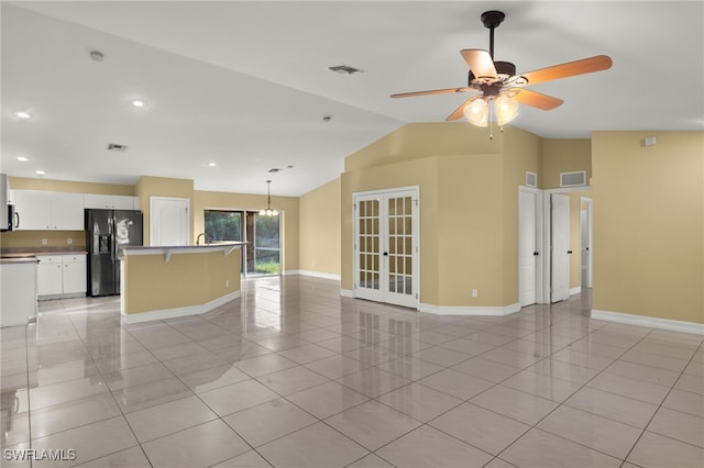 unfurnished living room featuring ceiling fan, light tile patterned flooring, lofted ceiling, and french doors