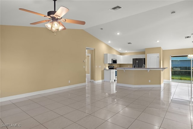 unfurnished living room featuring ceiling fan with notable chandelier, light tile patterned floors, and vaulted ceiling