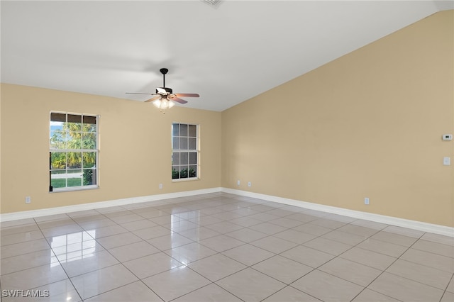 empty room featuring ceiling fan, light tile patterned floors, and vaulted ceiling