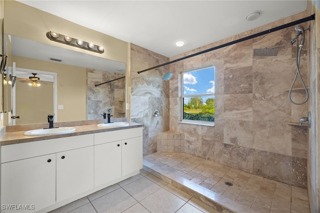 bathroom with tile patterned flooring, vanity, ceiling fan, and tiled shower