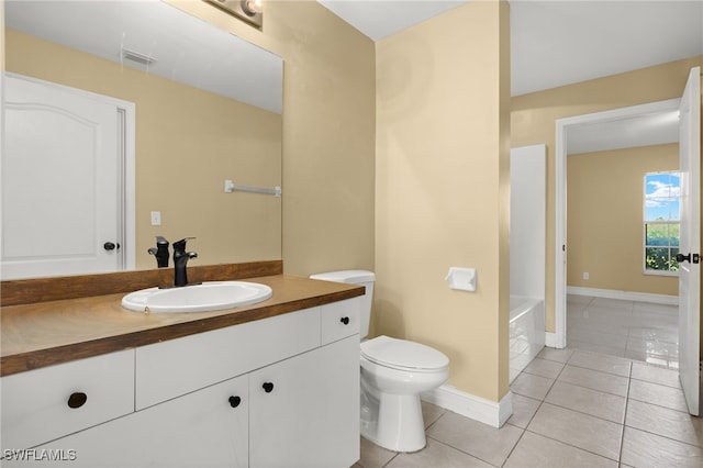 bathroom featuring tile patterned flooring, vanity, toilet, and a bathing tub