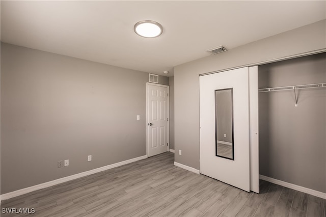 unfurnished bedroom featuring a closet and light wood-type flooring