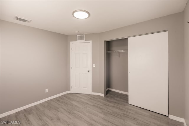 unfurnished bedroom featuring light wood-type flooring and a closet