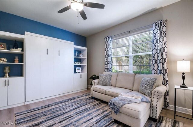 living room featuring ceiling fan and wood-type flooring