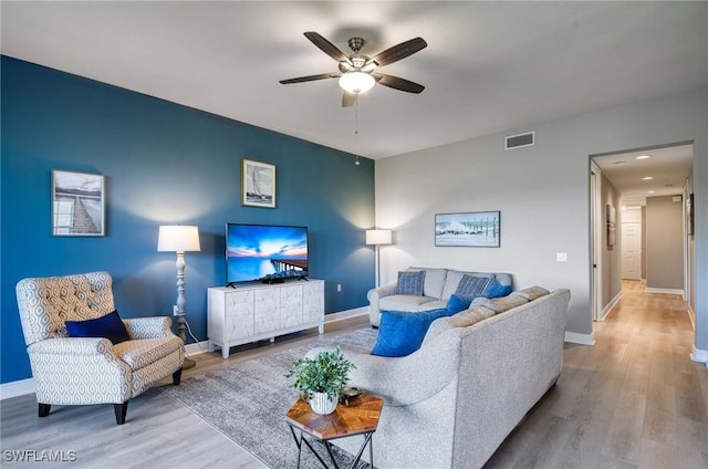 living room featuring ceiling fan and light hardwood / wood-style floors