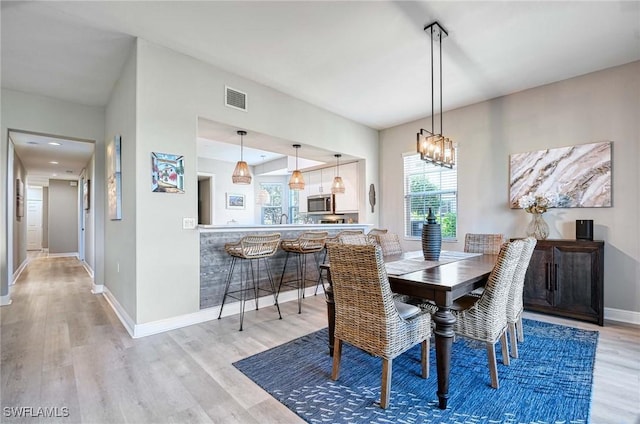 dining area featuring light hardwood / wood-style flooring and an inviting chandelier