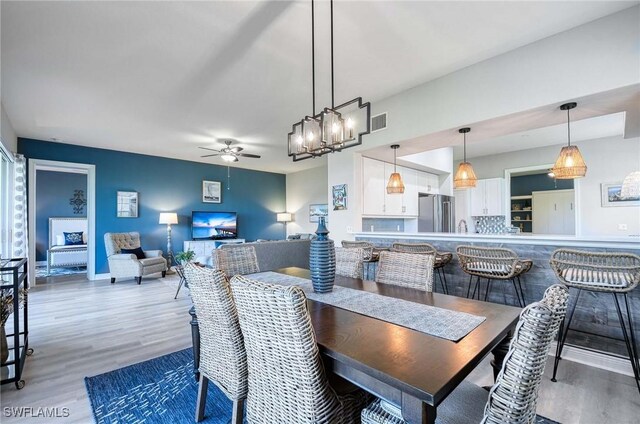 dining area with ceiling fan, sink, and hardwood / wood-style flooring