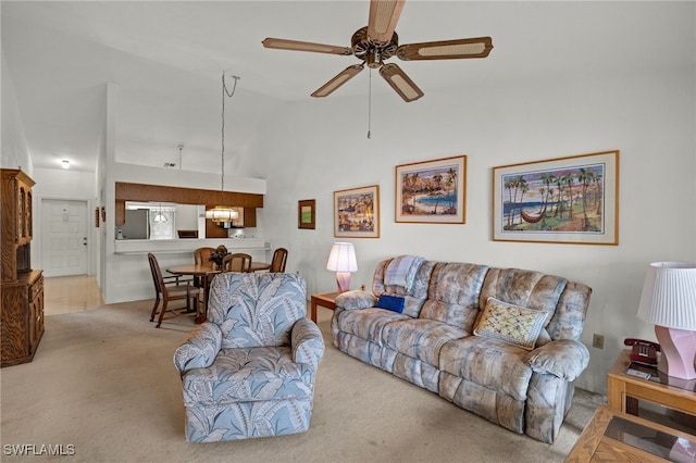 living room with light carpet, high vaulted ceiling, and ceiling fan with notable chandelier