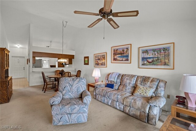 carpeted living area with high vaulted ceiling and a ceiling fan