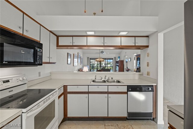 kitchen featuring white electric range oven, a sink, light countertops, black microwave, and dishwasher