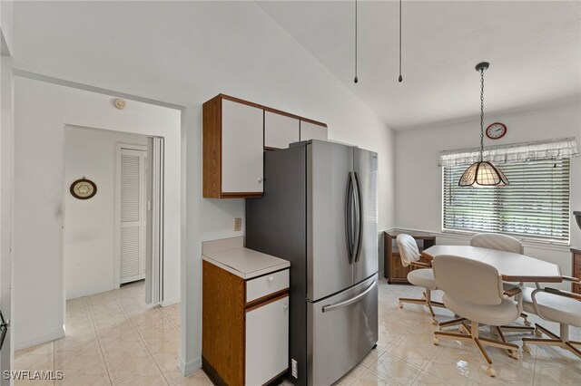 kitchen with decorative light fixtures, high vaulted ceiling, light countertops, and freestanding refrigerator