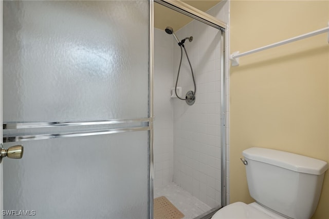 bathroom with an enclosed shower and toilet