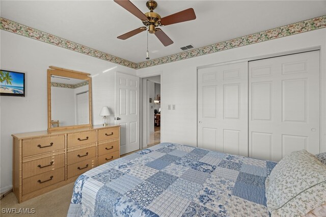 bedroom featuring light carpet, visible vents, a ceiling fan, and a closet