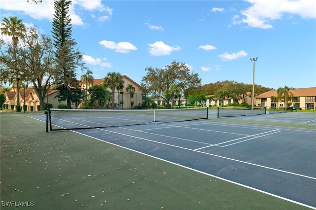 view of sport court with fence and a residential view