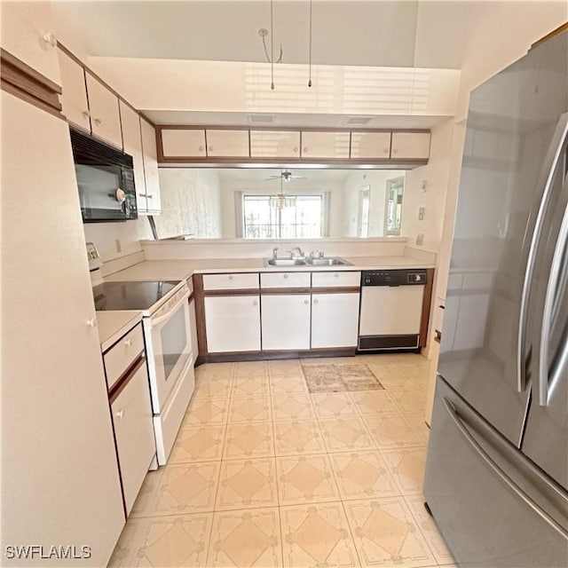 kitchen with white appliances, light floors, a sink, light countertops, and white cabinetry