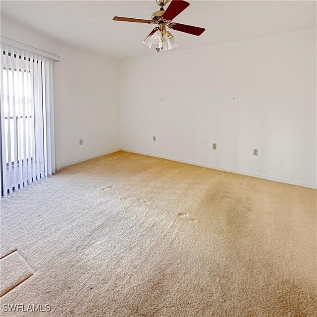 empty room featuring light colored carpet and ceiling fan