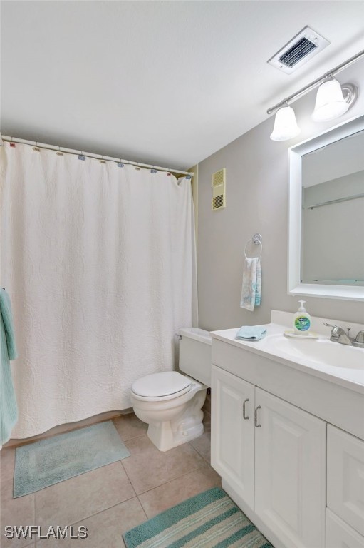 bathroom featuring tile patterned floors, vanity, and toilet