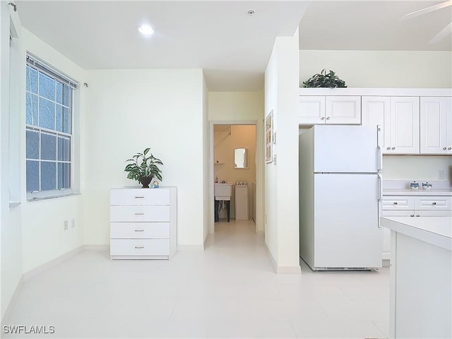 22700 Island Pines Way Unit 503, Fort Myers Beach, FL 33931 - kitchen with freestanding refrigerator, white cabinetry, light countertops, recessed lighting, and baseboards