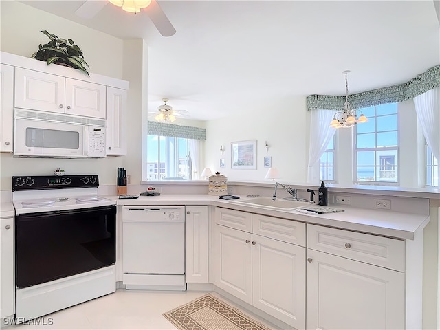 kitchen with sink, white cabinets, a healthy amount of sunlight, and white appliances