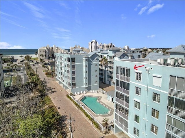 view of building exterior with a water view and a community pool