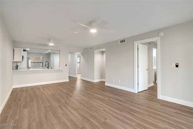 unfurnished living room featuring light hardwood / wood-style floors and ceiling fan