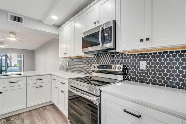 kitchen featuring stainless steel appliances, backsplash, sink, light hardwood / wood-style floors, and white cabinets