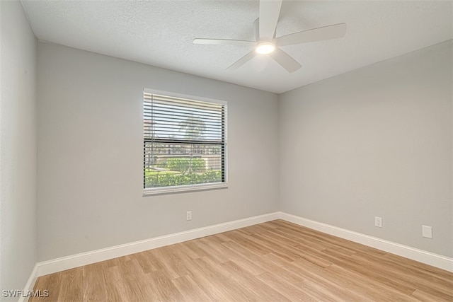 empty room with light hardwood / wood-style floors, ceiling fan, and a textured ceiling