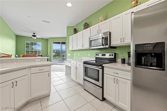 kitchen featuring stainless steel appliances, white cabinets, light tile patterned floors, ceiling fan, and light stone countertops