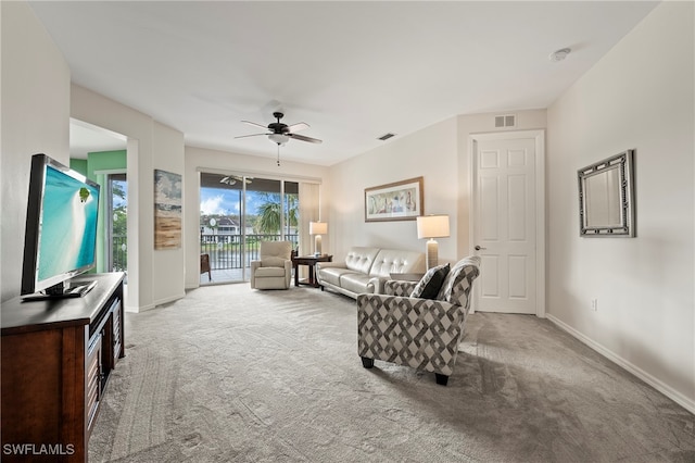 carpeted living room with ceiling fan