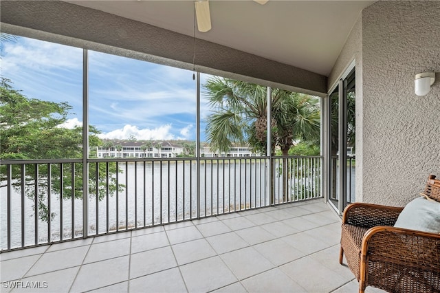 sunroom featuring a water view and ceiling fan