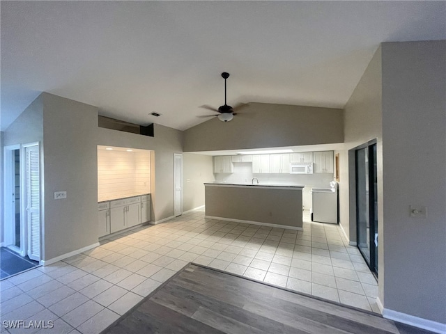 kitchen featuring lofted ceiling, ceiling fan, sink, and light tile patterned flooring