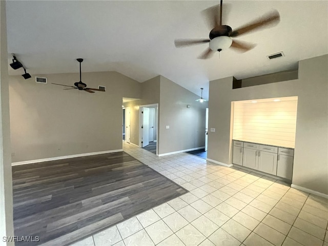 spare room with light hardwood / wood-style flooring, lofted ceiling, and ceiling fan