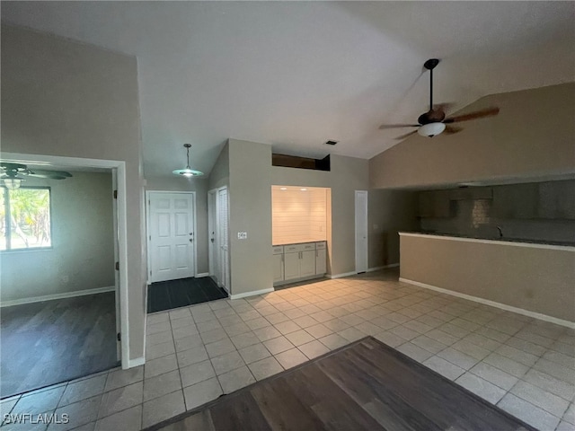 interior space featuring high vaulted ceiling, ceiling fan, and light tile patterned flooring