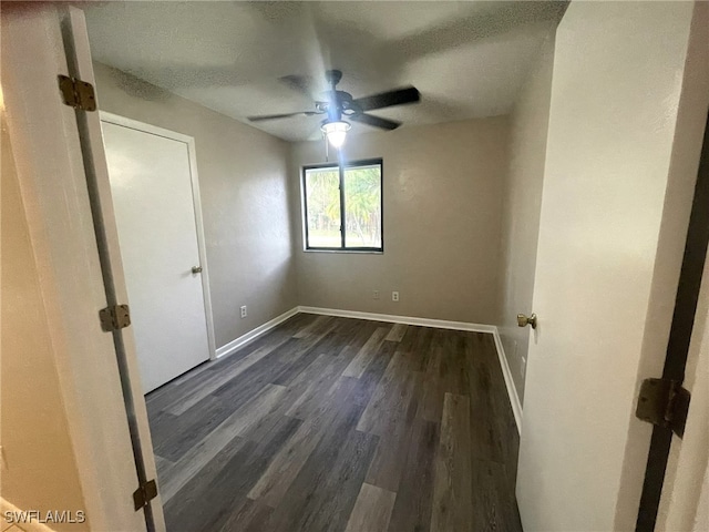 unfurnished room featuring ceiling fan and dark hardwood / wood-style floors