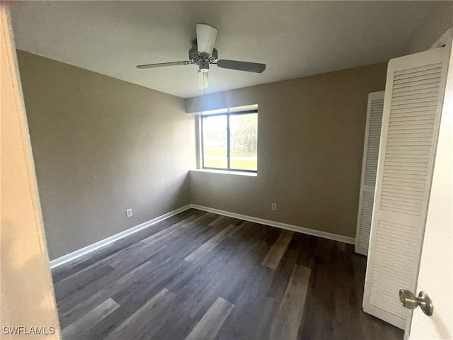 unfurnished bedroom with dark wood-type flooring, ceiling fan, and a closet