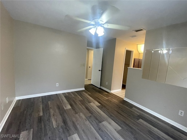 spare room with dark hardwood / wood-style flooring and ceiling fan