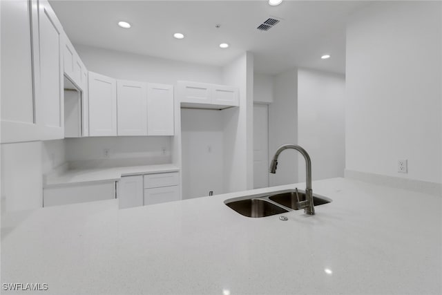 kitchen featuring white cabinetry and sink