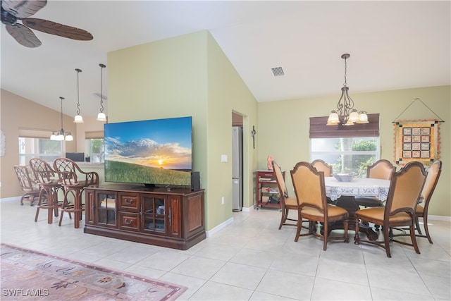 dining area featuring high vaulted ceiling, light tile patterned flooring, and ceiling fan with notable chandelier