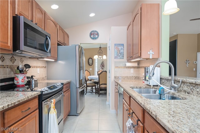 kitchen featuring stainless steel appliances, light tile patterned flooring, pendant lighting, light stone counters, and sink