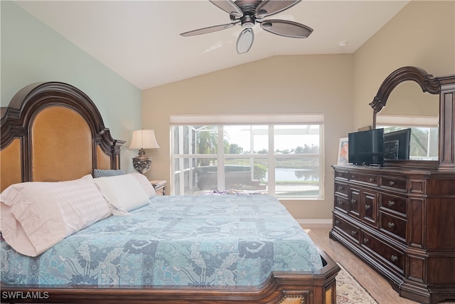 bedroom featuring ceiling fan, light hardwood / wood-style flooring, multiple windows, and lofted ceiling