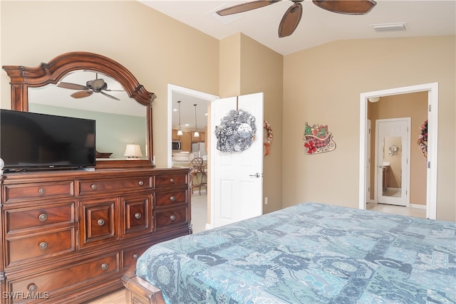 bedroom featuring vaulted ceiling, ceiling fan, and stainless steel fridge