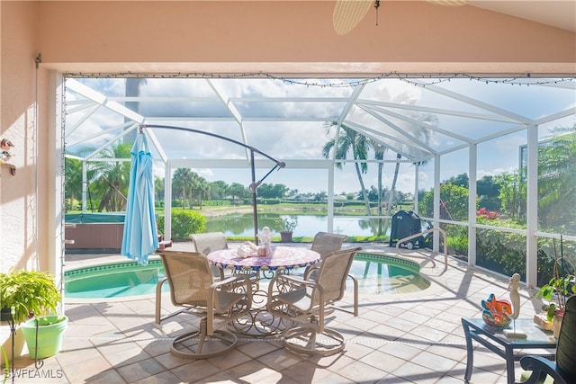 view of patio / terrace featuring a water view, a swimming pool with hot tub, and glass enclosure