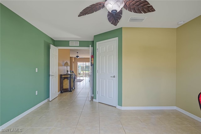 tiled spare room featuring ceiling fan