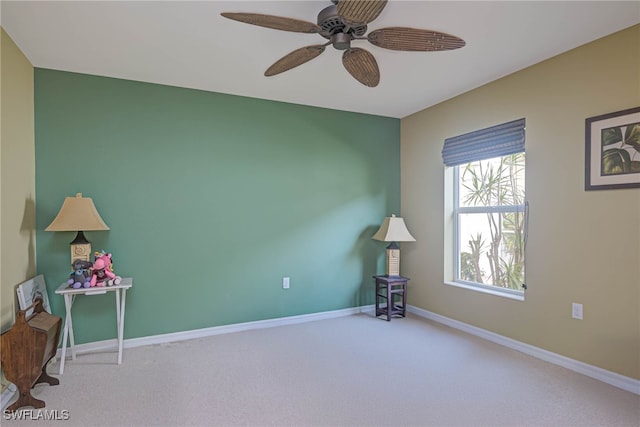 carpeted spare room with ceiling fan